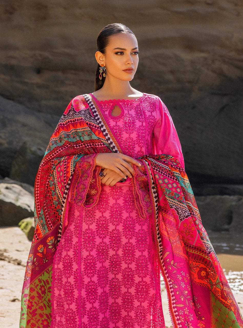 Woman wearing a vibrant pink traditional outfit with intricate patterns against a natural background