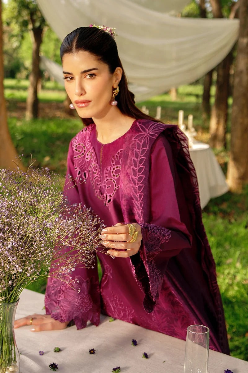 Woman in a purple embroidered dress holding flowers outdoors