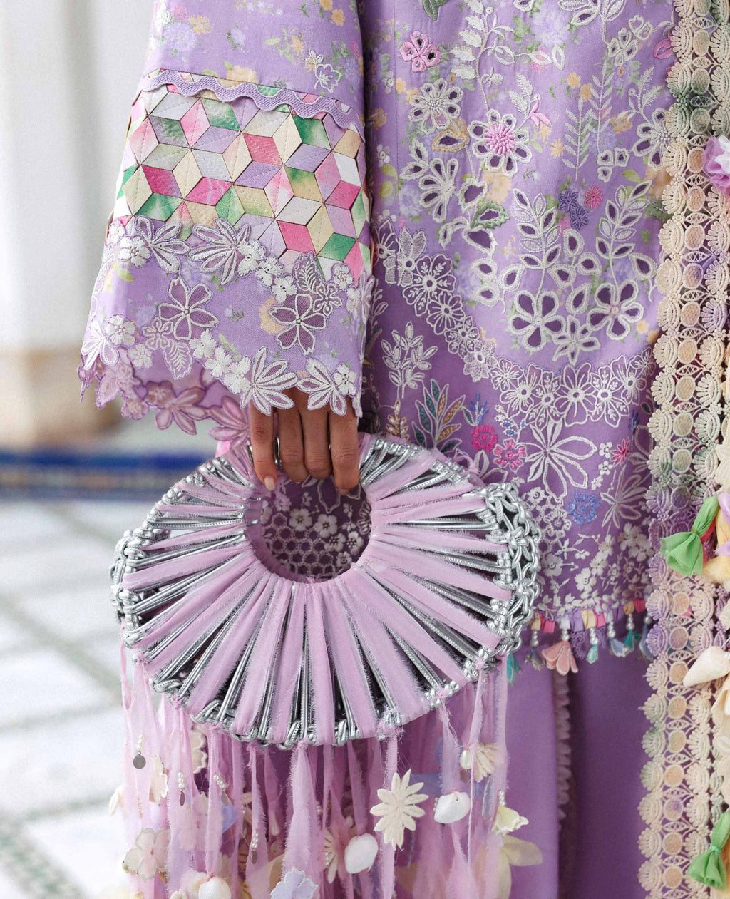 Person wearing a floral dress holding a matching handbag with a blurred background