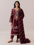 A woman modeling a deep maroon three-piece ethnic suit with intricate white embroidery, featuring a long kurta, matching trousers, and a draped dupatta, set against a solid light beige background.