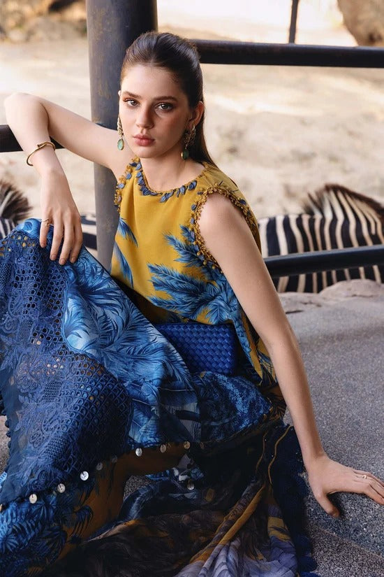 Woman in a yellow top with blue floral pattern and blue skirt sitting outdoors with zebras in the background
