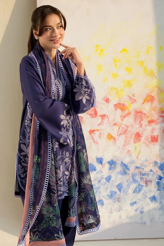 Woman wearing a long, patterned dress in front of a colorful abstract painting.