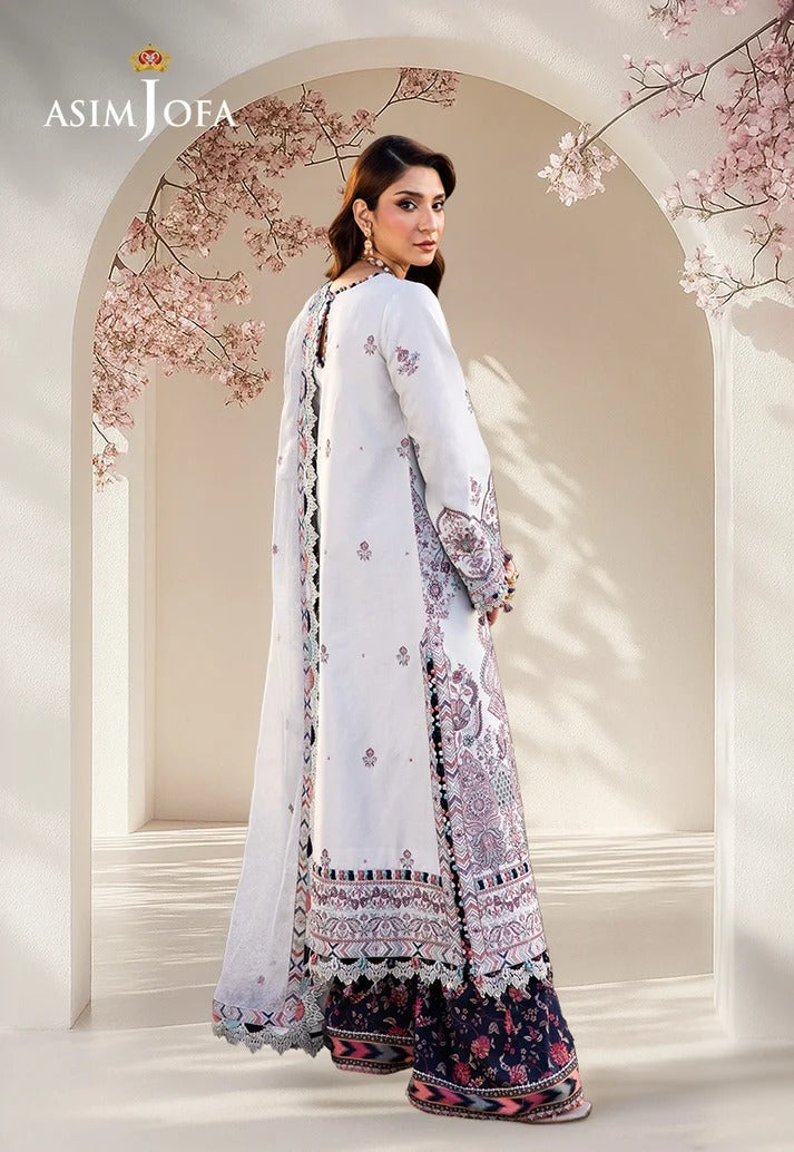 Woman in a white and floral traditional outfit with 'Asim Jofa' branding, standing in front of an archway with cherry blossoms.