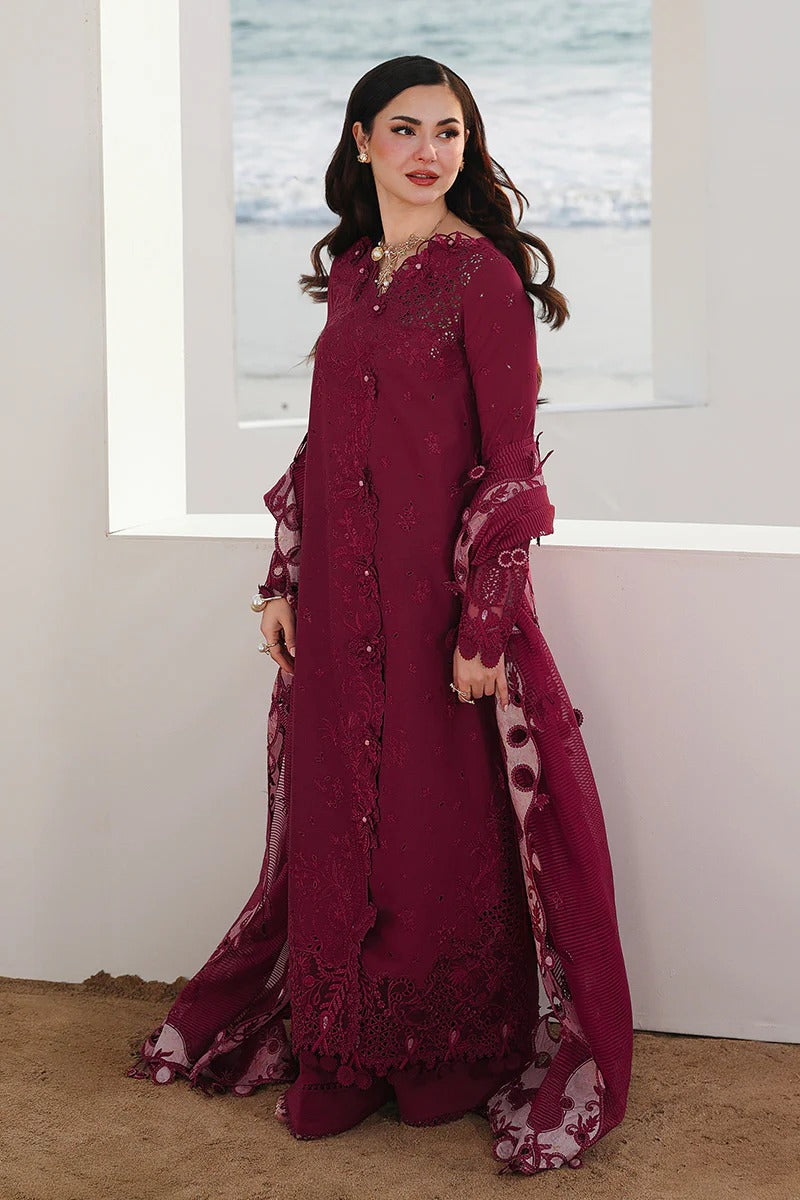 Woman wearing a burgundy embroidered dress with a matching dupatta in a minimal indoor setting.