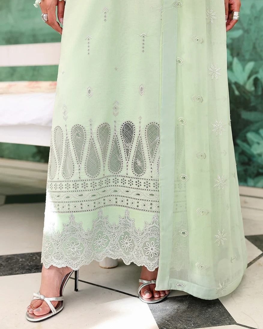 Light green dress with lace details worn by a person, standing on a checkered floor.