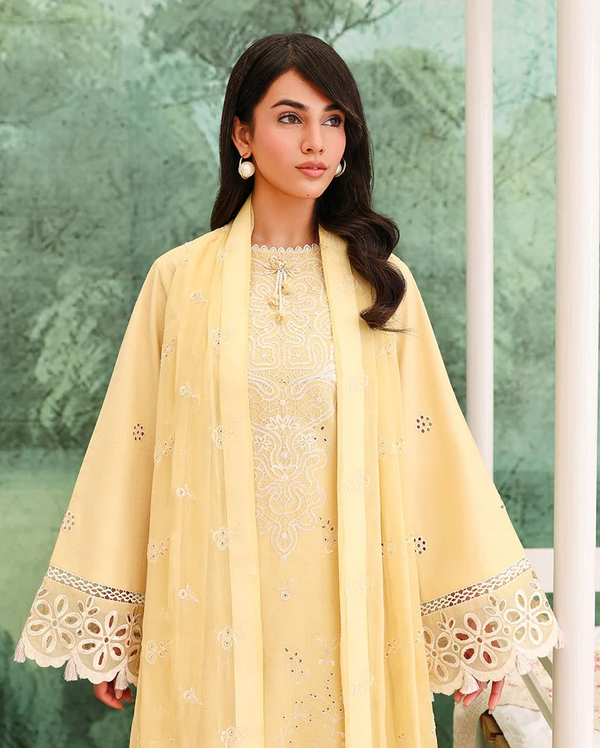 Woman wearing a yellow embroidered outfit with a green leafy background