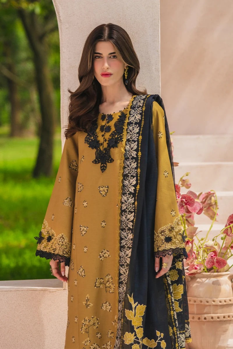 Woman wearing a mustard and navy embroidered outfit with floral decorations in an outdoor setting.