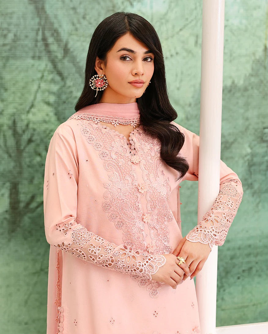 Woman wearing a pink embroidered outfit against a green background