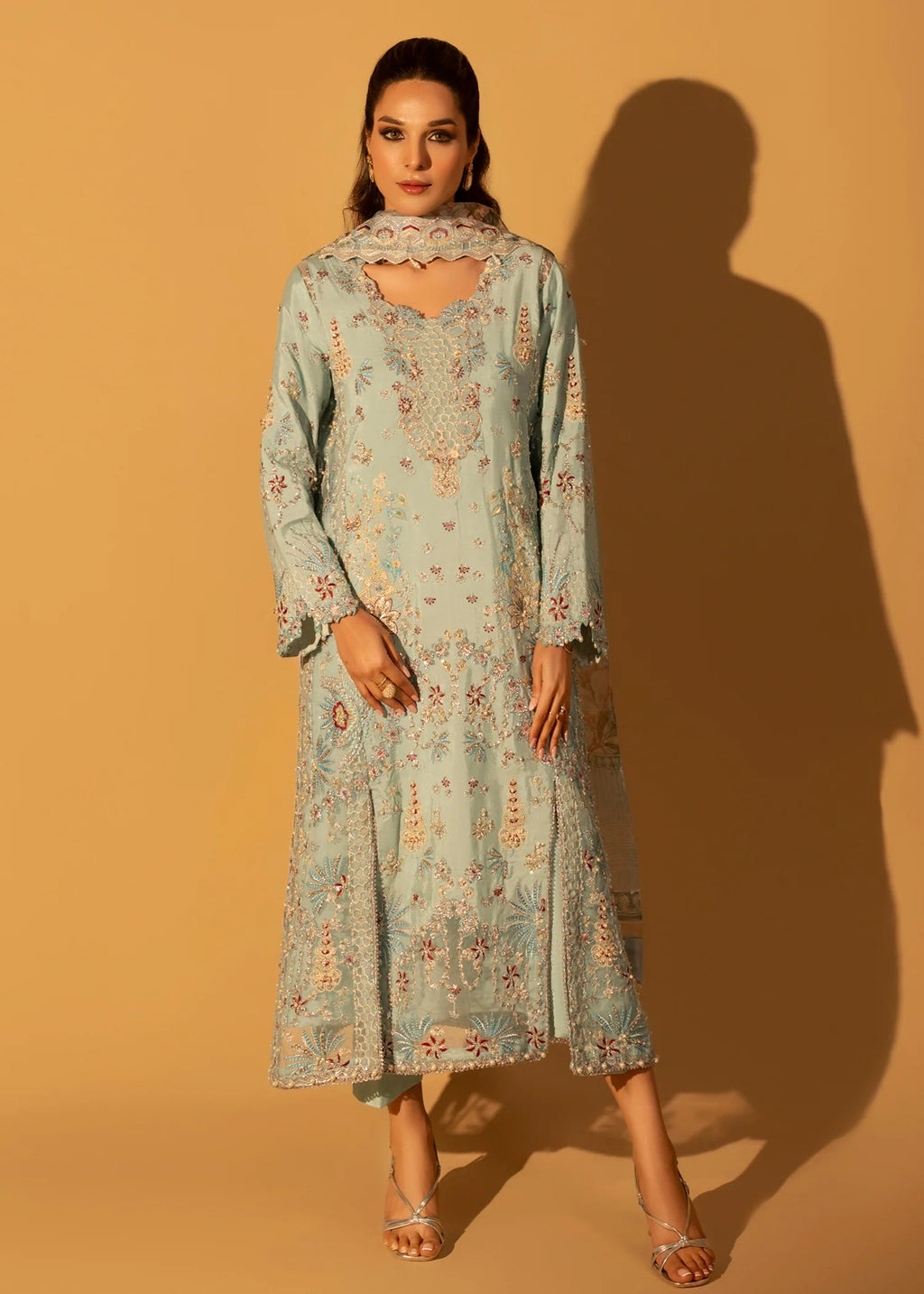 Woman wearing a light blue floral dress against a beige background