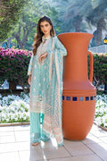 Woman in a light blue traditional outfit standing next to a large decorative vase outdoors.