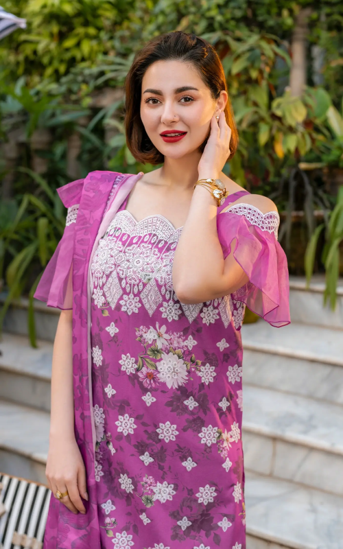Woman in a pink floral dress with a matching shawl outdoors.