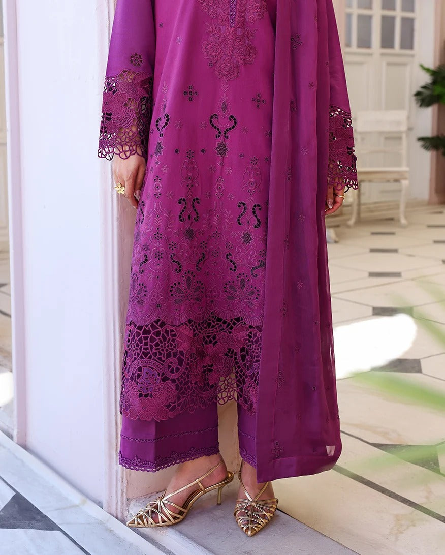 Purple embroidered outfit with gold sandals on a neutral background