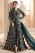 A woman models a long teal and gold embroidered Anarkali gown with a matching dupatta in an elegant indoor setting with classical columns and a statue.