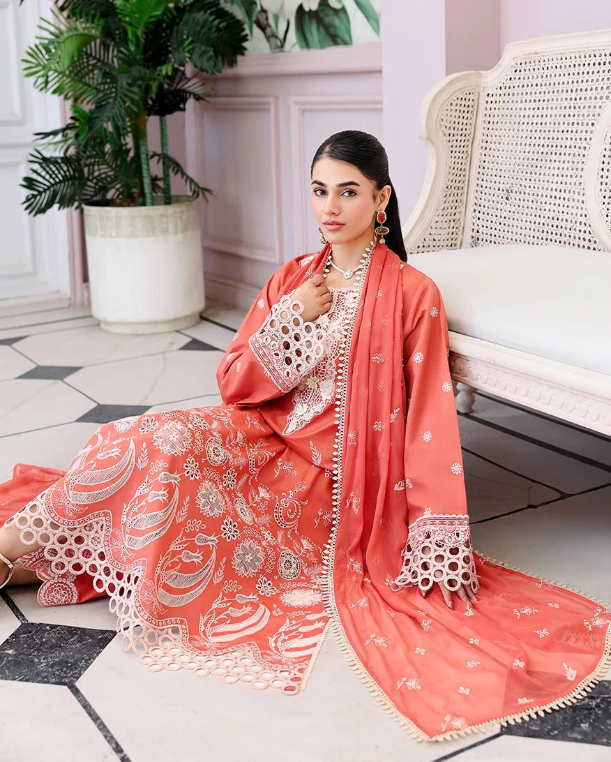 Woman in a coral traditional outfit with white patterns sitting on a white chair.