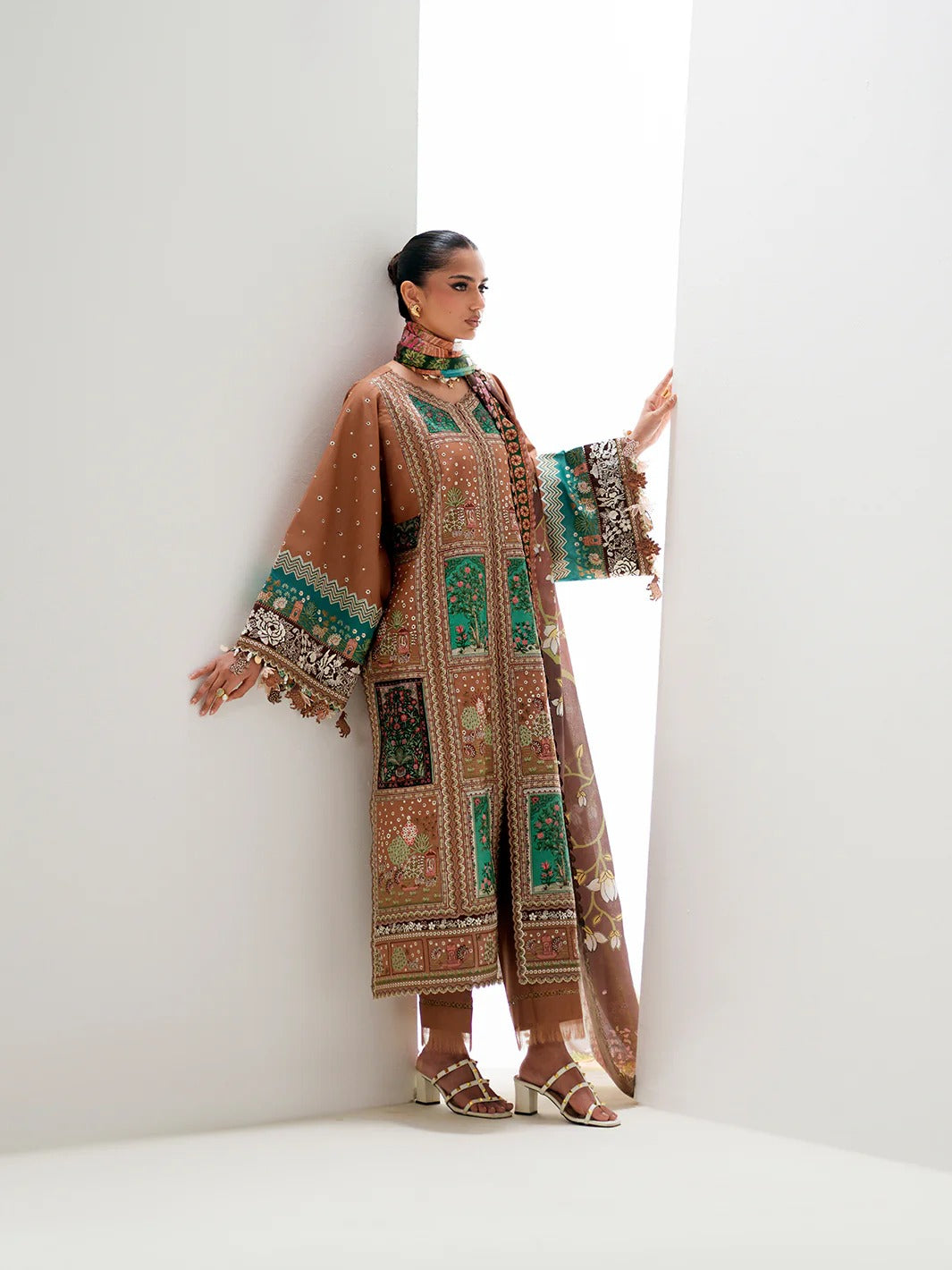 Woman wearing a traditional embroidered outfit against a white background