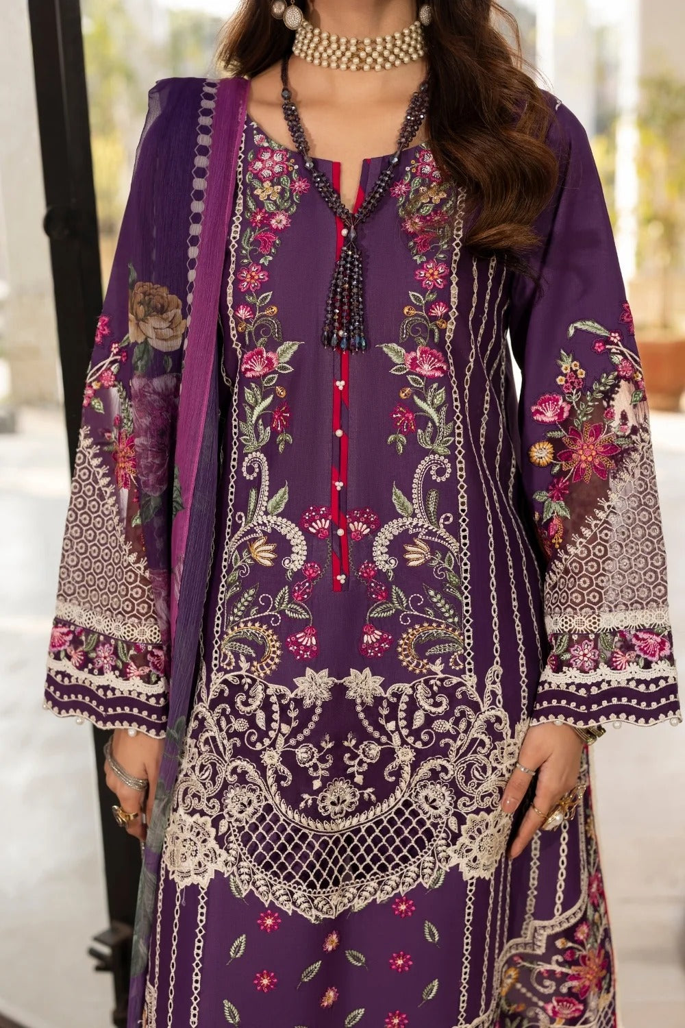 Woman wearing a purple embroidered traditional outfit with a blurred background