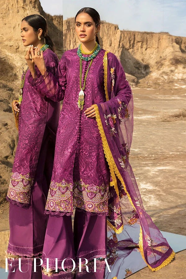 Two women modeling a purple embroidered traditional outfit with matching dupatta in an outdoor desert canyon setting. The outfit features intricate gold and multicolor embroidery, a gold-trimmed neckline, and wide-leg trousers.