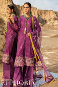 Two women modeling a purple embroidered traditional outfit with matching dupatta in an outdoor desert canyon setting. The outfit features intricate gold and multicolor embroidery, a gold-trimmed neckline, and wide-leg trousers.