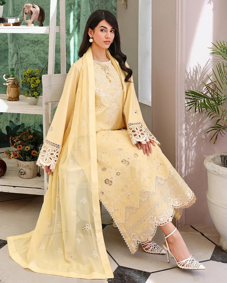 Woman in a yellow embroidered outfit standing in a room with plants and decor.