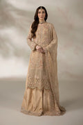 A woman models a traditional beige embroidered Anarkali suit with a matching sheer dupatta, set against a soft, textured beige studio backdrop.