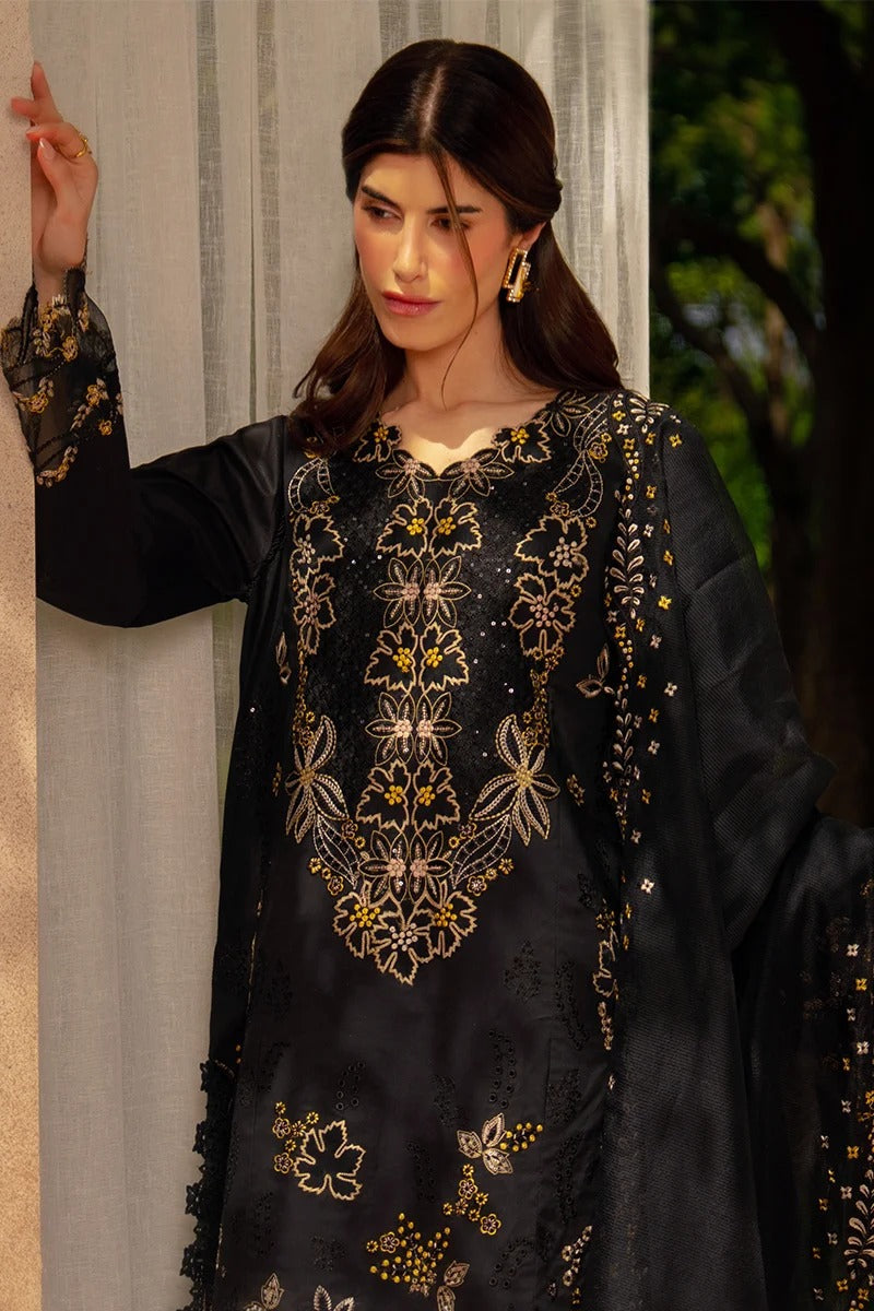 Woman wearing a black embroidered traditional outfit with gold details.