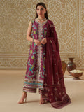 Woman wearing a traditional embroidered outfit in a decorated room.