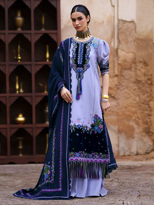 A woman models a traditional South Asian salwar kameez suit. The outfit features a lavender kameez kurta with intricate multicolor floral embroidery and a navy blue border, paired with a matching navy blue dupatta.