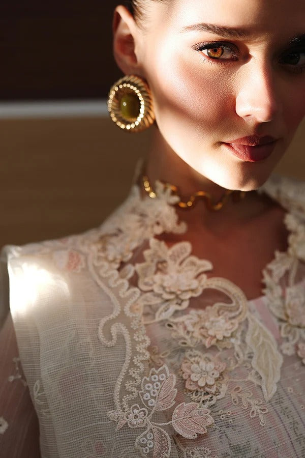 Close-up of a woman wearing gold earrings and a lace garment.