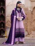 A woman models a traditional South Asian salwar kameez suit in lavender purple and deep purple. The outfit features a lavender kurta with a deep purple border, matching lavender trousers, and a deep purple dupatta with intricate embroidery.