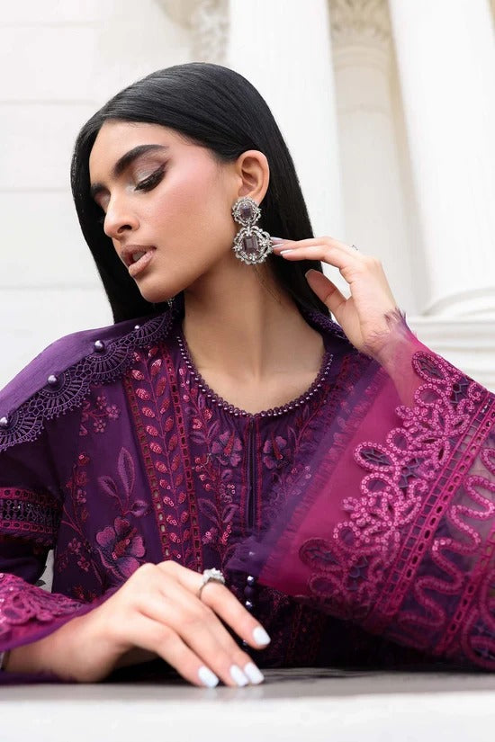 Woman wearing a purple embroidered outfit with a white background