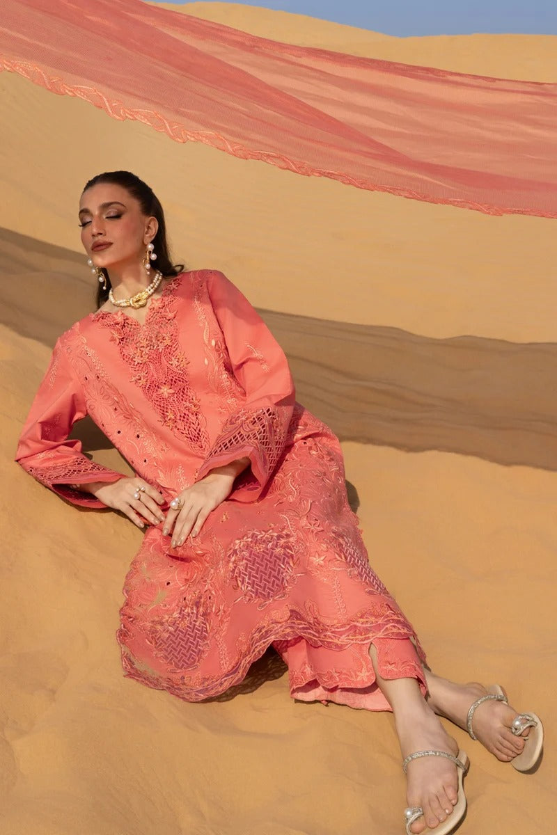 Woman in a pink traditional outfit sitting on sand dunes