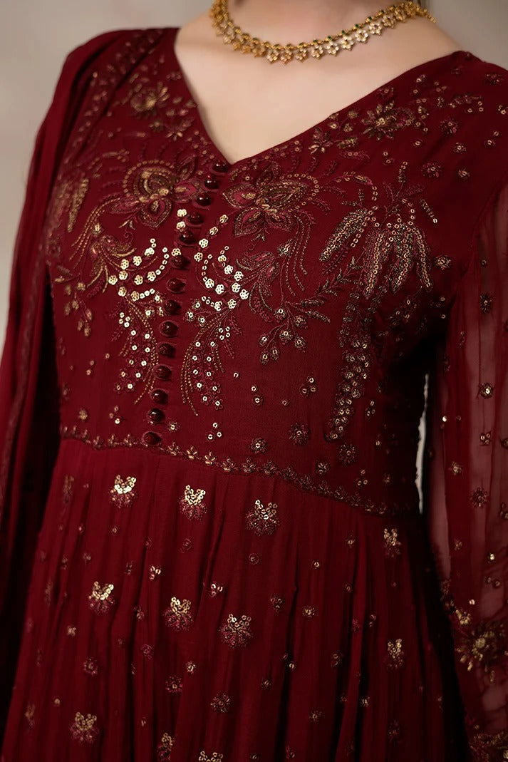 A close-up of a deep maroon red embroidered dress featuring intricate gold sequin and bead work, a V-neckline, and a matching sheer dupatta draped over the shoulder.