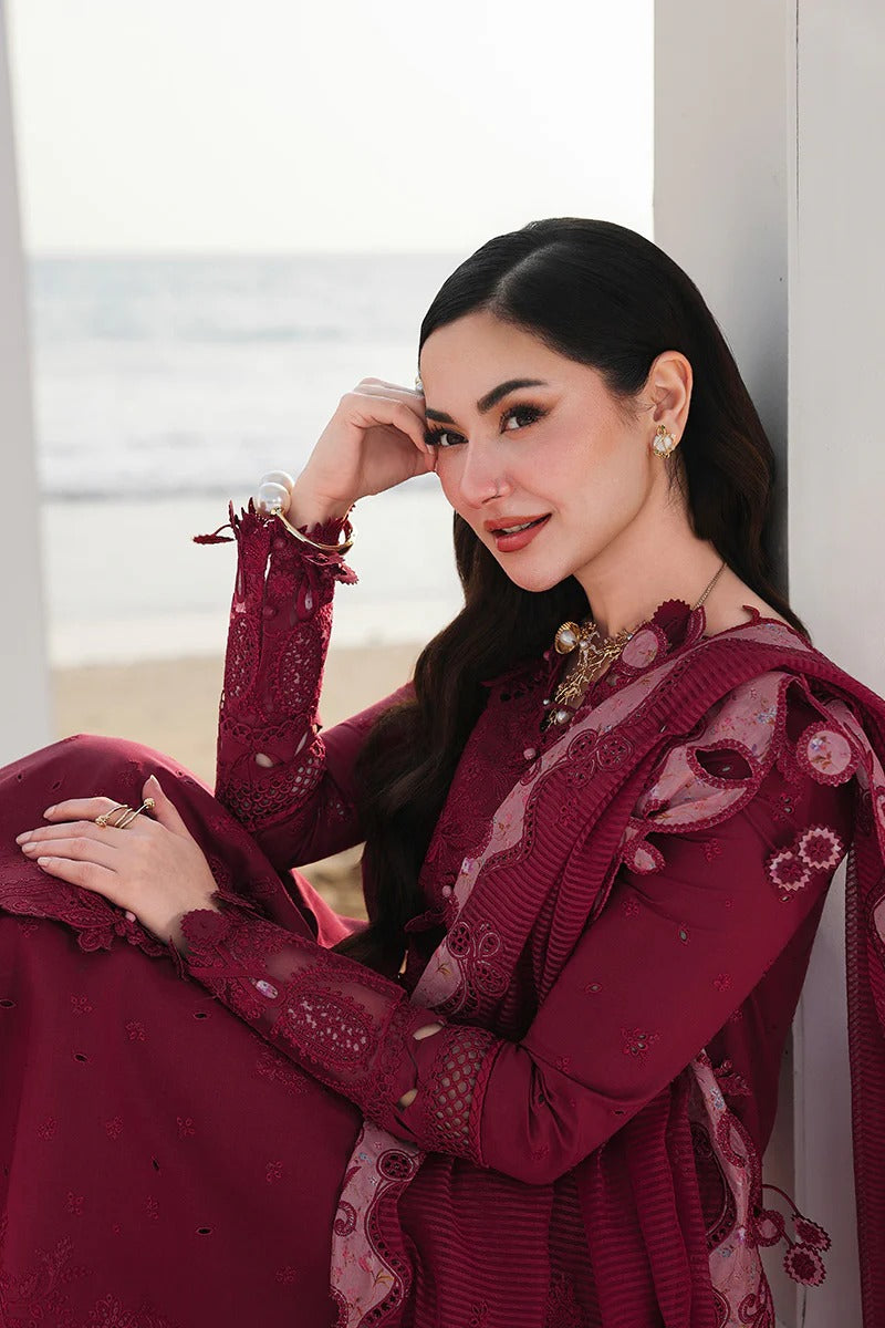 Woman in a burgundy traditional outfit with floral patterns indoors.