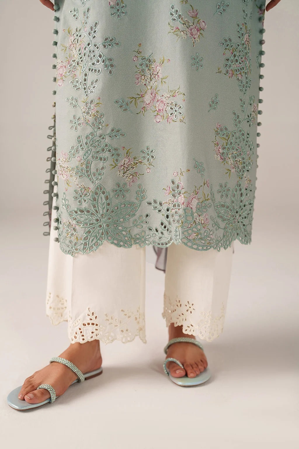 Light blue floral dress with white lace pants on a plain background