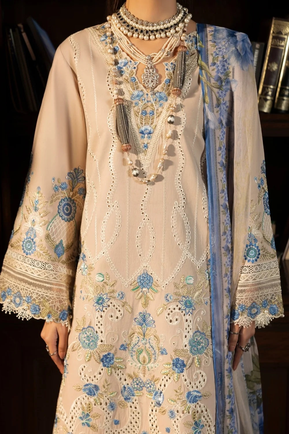 Beige embroidered dress with blue floral patterns on a dark background