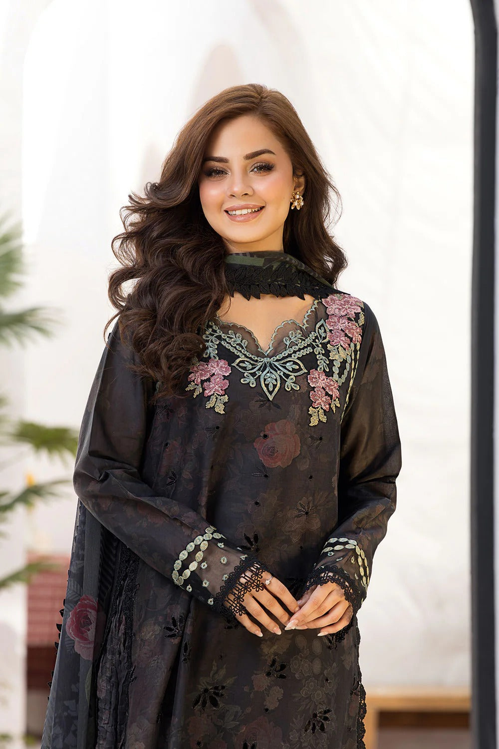 Woman wearing a black embroidered traditional outfit with a blurred background