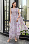 Woman in a light purple embroidered outfit with a floral dupatta standing in front of a glass door.