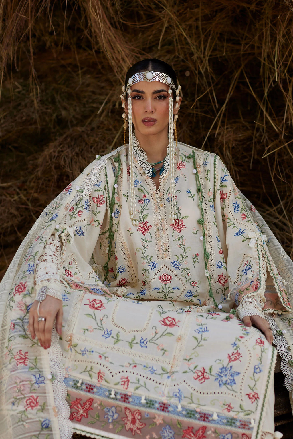 Woman in traditional embroidered outfit sitting against a natural background