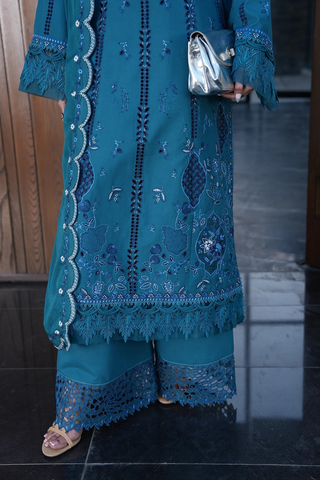 Blue embroidered traditional outfit on a reflective floor