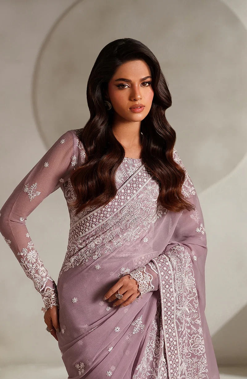 Woman wearing a lavender saree with white embroidery against a neutral background