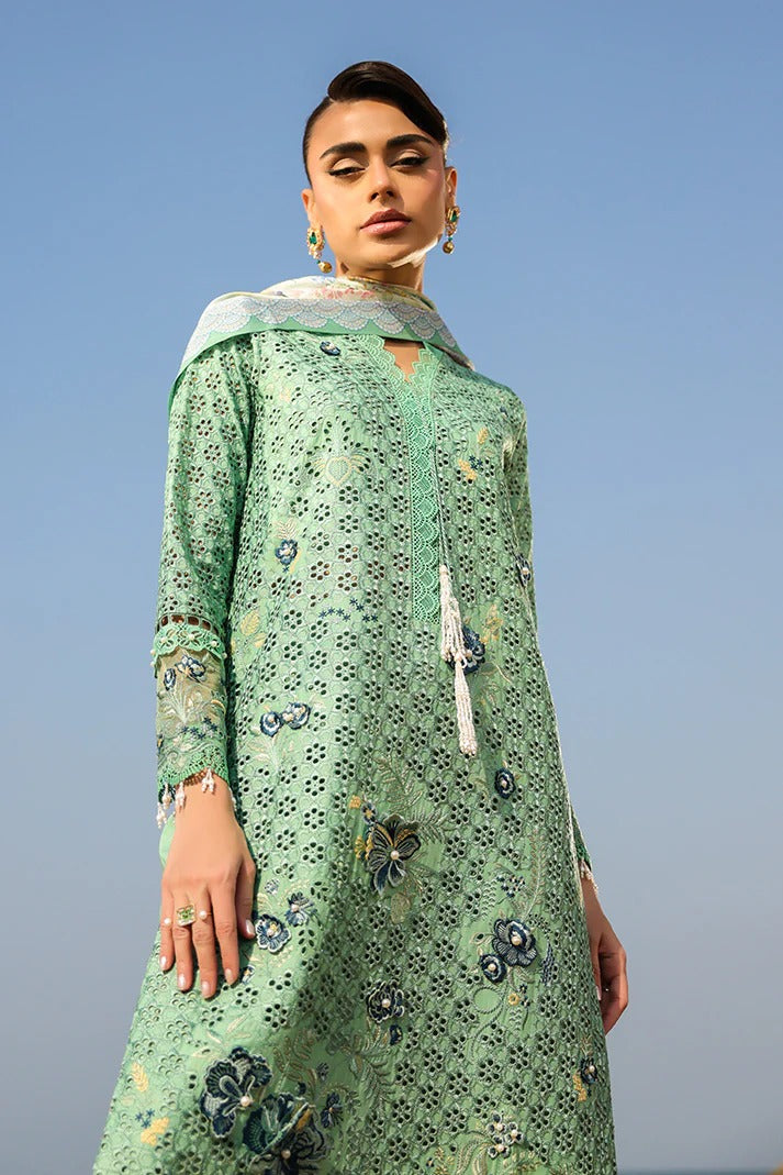 Woman wearing a green floral dress against a clear blue sky