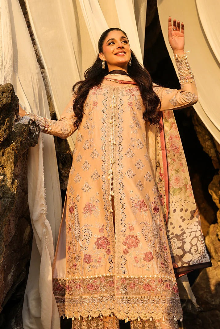 Woman in a traditional embroidered outfit standing against a draped curtain.