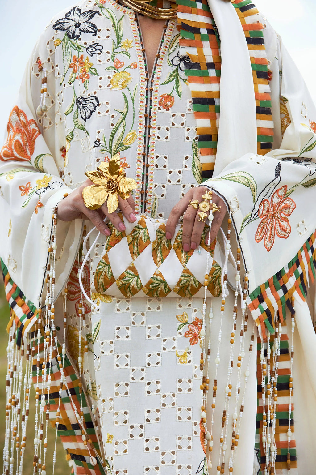 Colorful traditional outfit with floral patterns and a matching clutch.