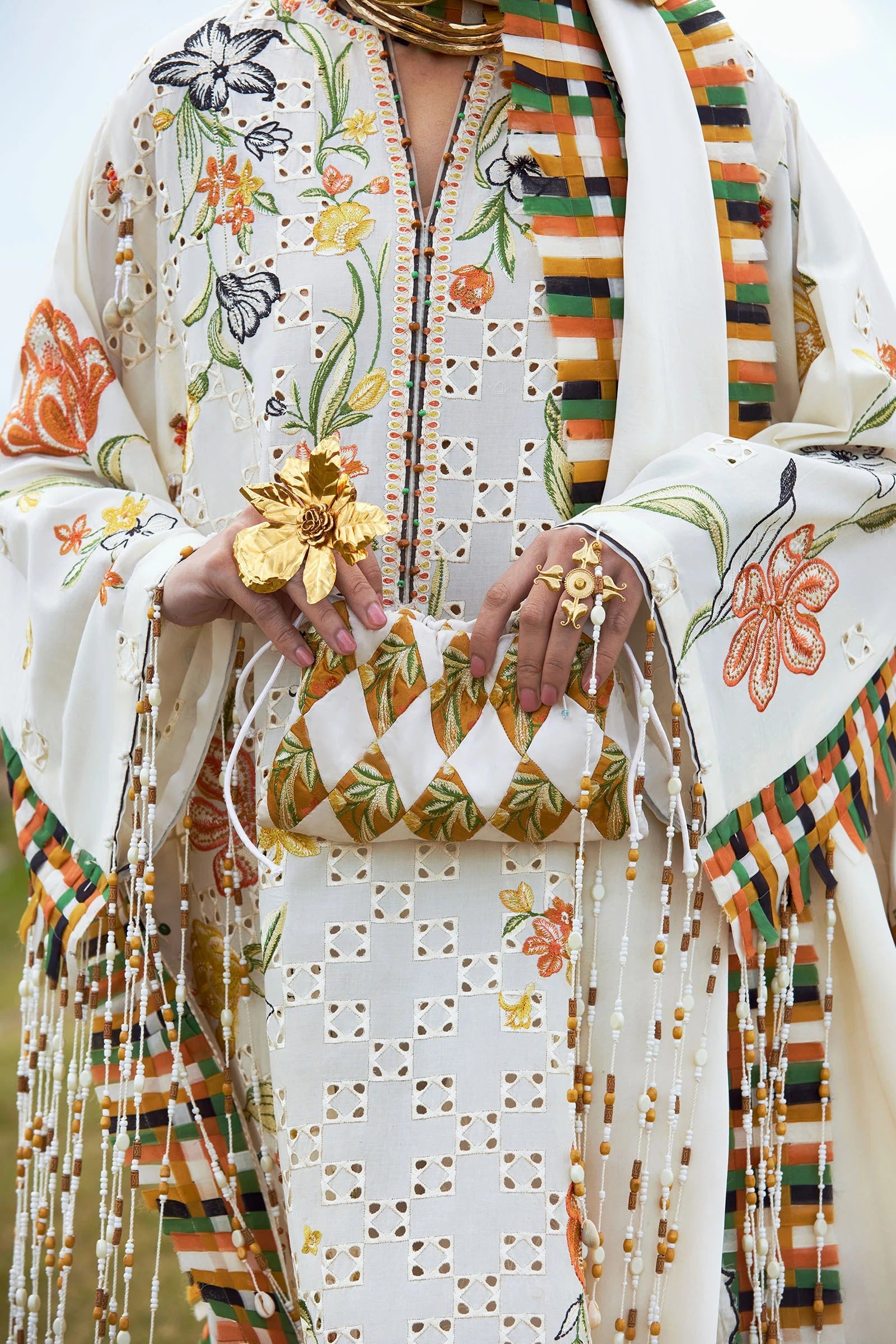 Colorful traditional outfit with floral patterns and a matching clutch.