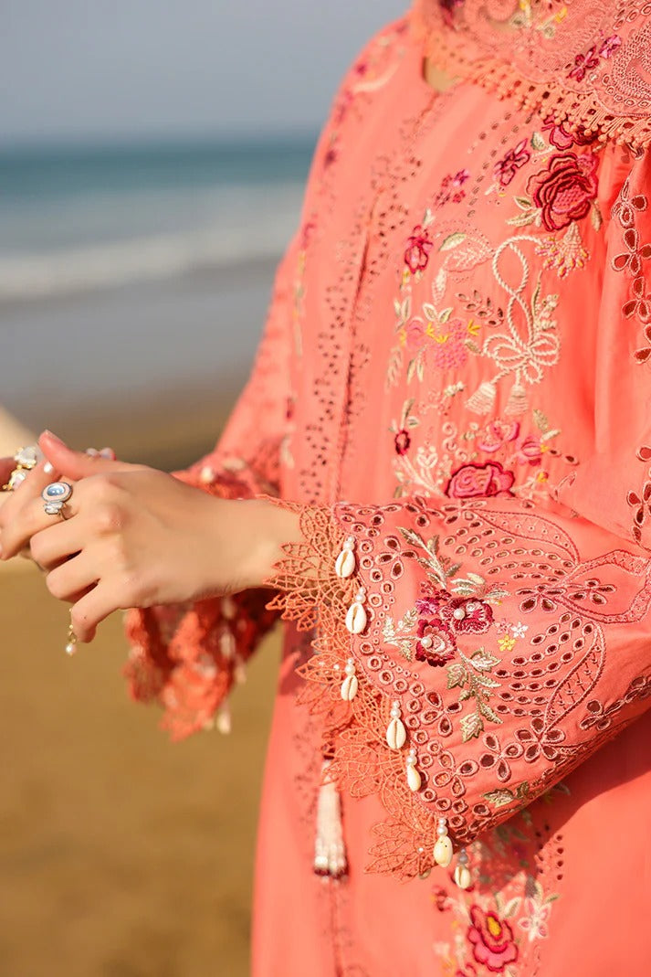 Coral embroidered garment with a blurred beach background