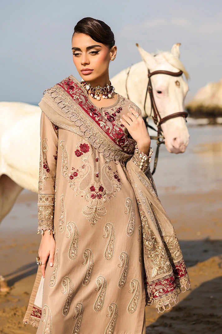 Woman in traditional embroidered outfit standing next to a white horse on a beach.