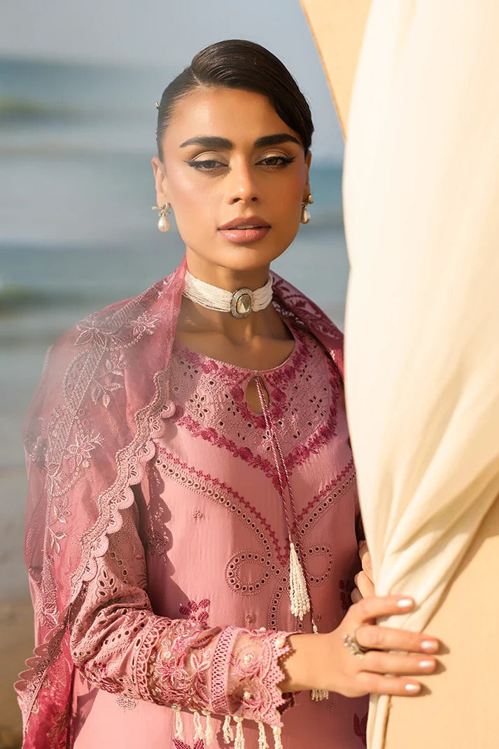Woman in a pink traditional outfit with a blurred beach background