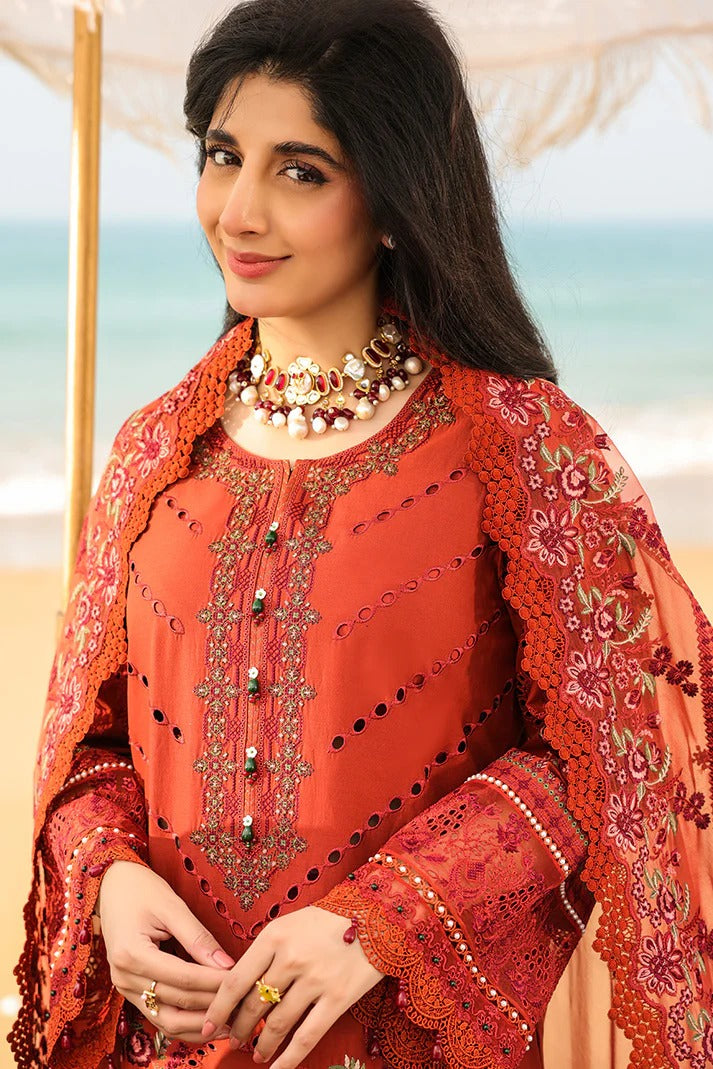 Woman wearing an orange embroidered traditional outfit with a blurred outdoor background