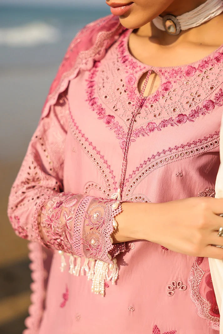 Person wearing a pink embroidered outfit with a blurred background