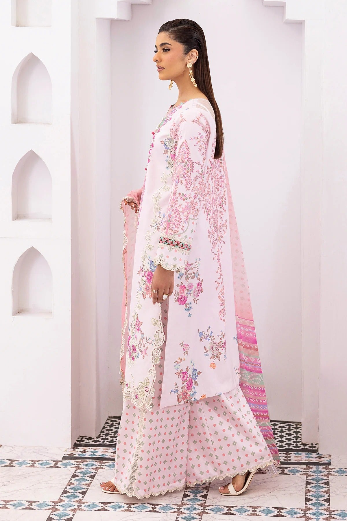 Woman in a floral outfit standing in a decorative interior setting